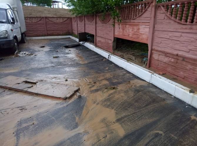 В Брянске потоки воды снесли две секции бетонного забора на Пилотов