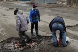 В Белых Берегах подростки сами заделали ямы на дорогах