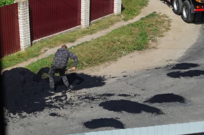 В Добруни неизвестный мужчина заделал асфальтом ямы на дороге
